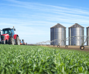 Agriculture and food production concept with tractor machine silos and irrigation system.