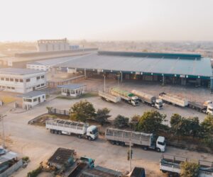 Aerial shot of factory trucks parked near the warehouse at daytime